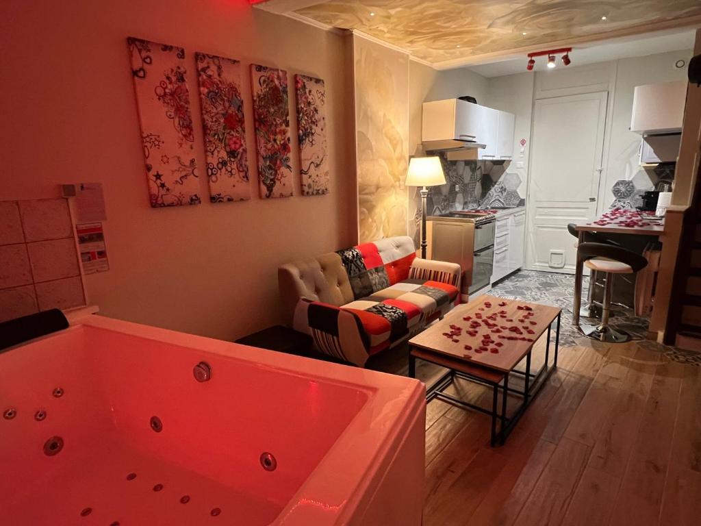 sala de estar con bañera grande en una habitación en À HOME LOVE-SPA, le plus luxueux parmi nos 2 établissements, en Montluel