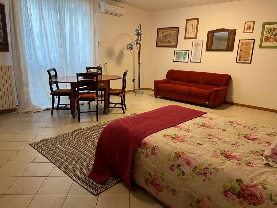 ein Schlafzimmer mit einem Bett, einem Tisch und einem Sofa in der Unterkunft Dimora Provenzali in Cento