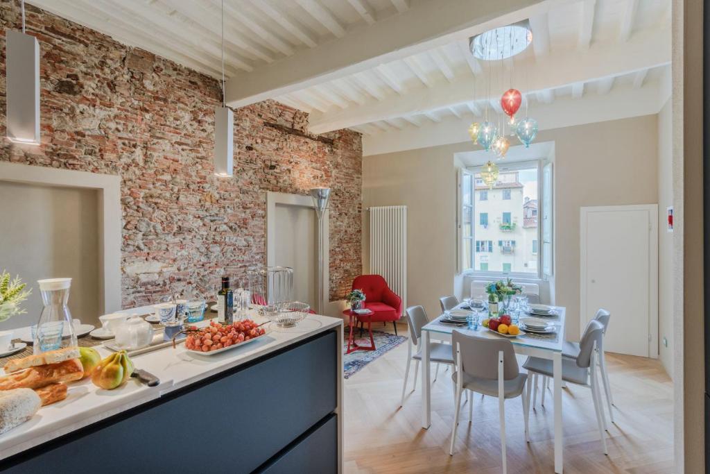 a kitchen and dining room with a brick wall at Casa Pino 2 bedrooms 2 bathrooms contemporary apar in Lucca