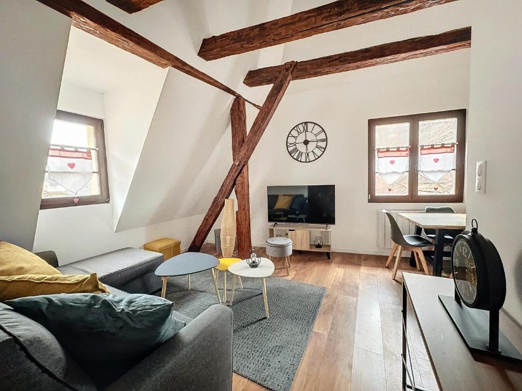 uma sala de estar com um sofá e uma mesa em Le Gite du Kaiser em Kaysersberg