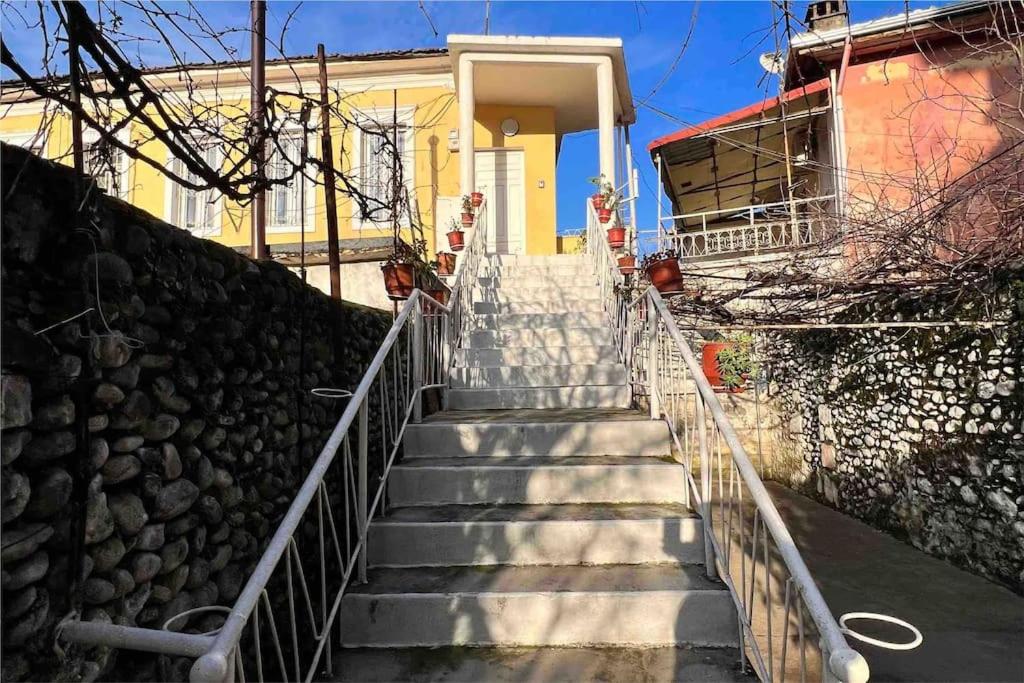 a set of stairs leading to a yellow house at Villa Rroji in Shkodër