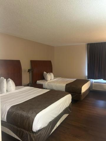 a hotel room with two beds and a window at Baymont by Wyndham Battle Creek/I-94 in Battle Creek