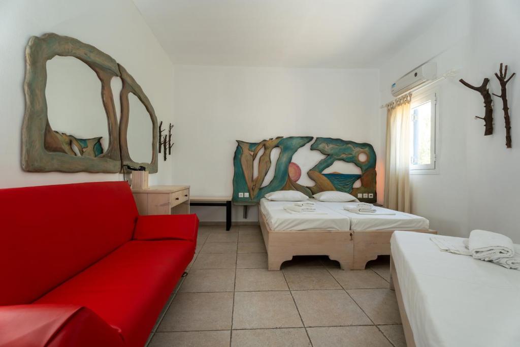 a living room with two beds and a red couch at Fanari Art in Ios Chora