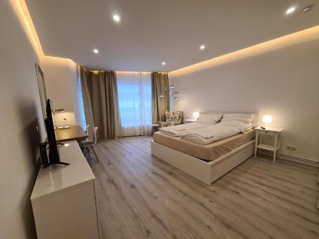 Soleil Rooms - Pure Living in the City Center في هانوفر: غرفة نوم فيها سرير وتلفزيون