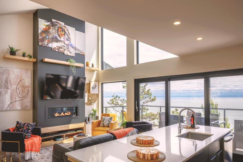 a kitchen and living room with a view of the ocean at Villa Villa Expérience-Villa de la Falaise, spa in Saint-Irénée