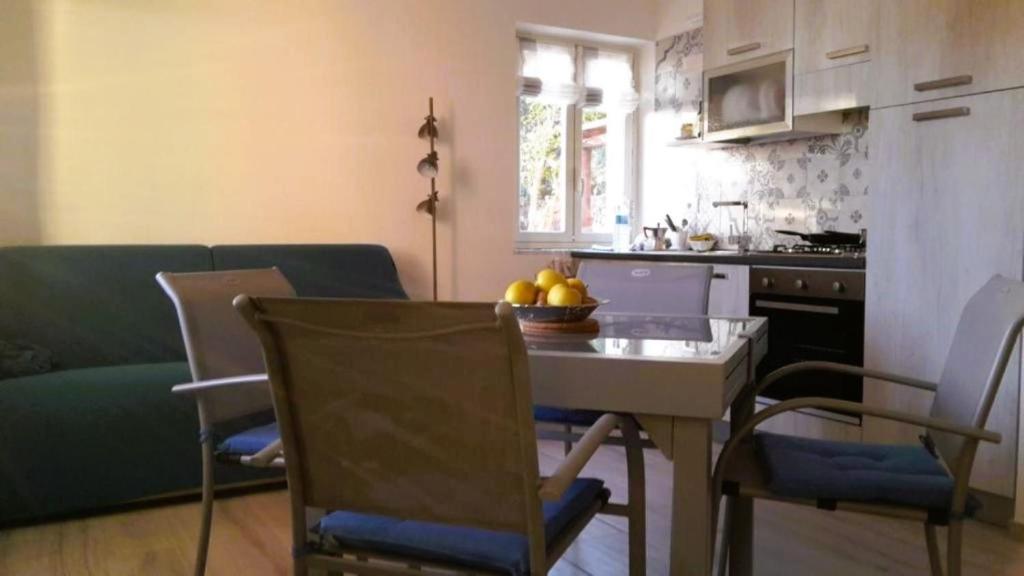cocina y sala de estar con mesa y sillas en Casa del Geco, en Rinella
