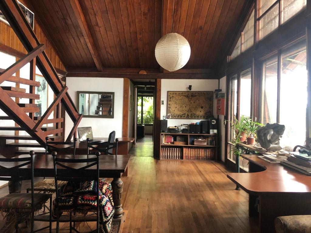 een woonkamer met houten plafonds en een tafel en stoelen bij Casa Bosquemar in Concón