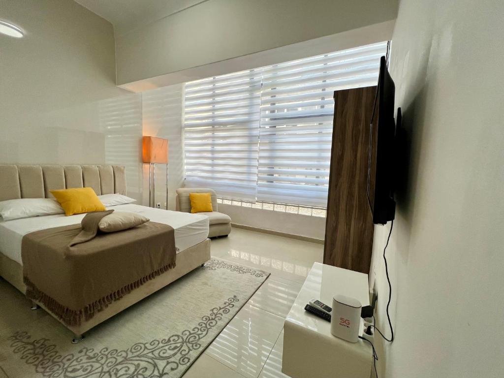 a bedroom with a bed and a tv and a window at Blue Sea Studio 1 minute away from Luanda Bay in Luanda