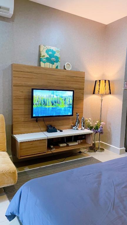 a living room with a flat screen tv on a wall at Cozy Stay at Shaftsbury Residences by SNS HOMES in Cyberjaya
