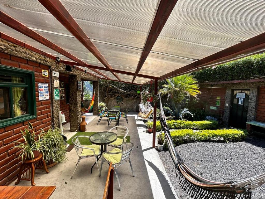an outdoor patio with chairs and a table and awning at La Casa del Molino Blanco B&B in Baños