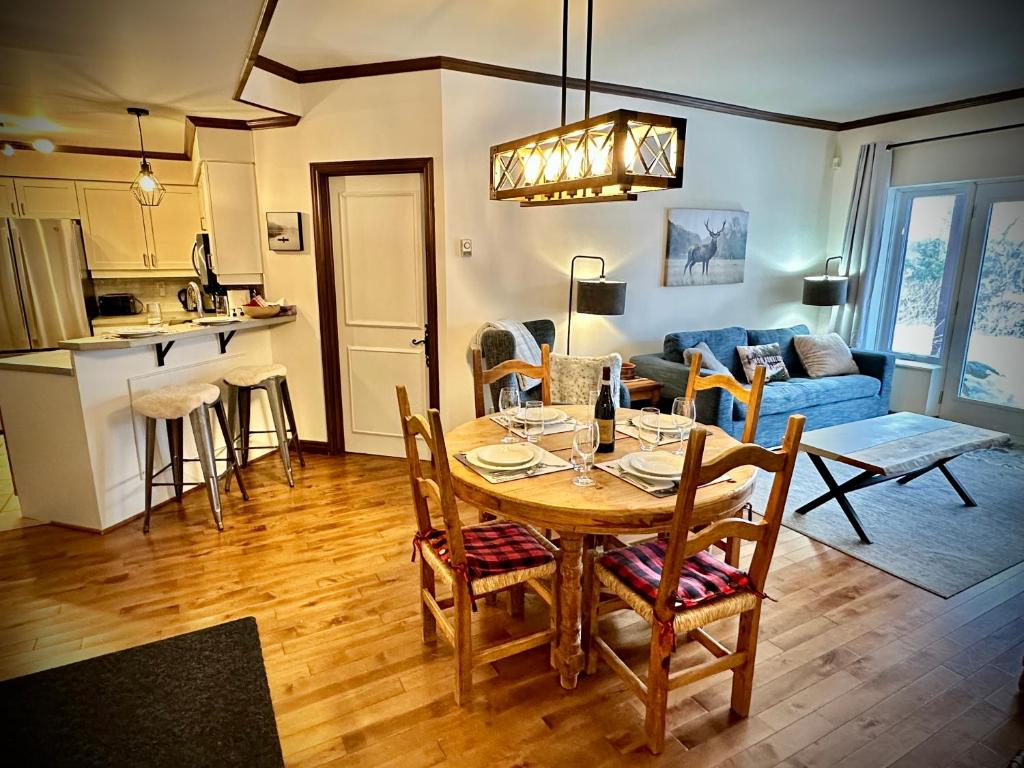 a kitchen and living room with a table and chairs at L'Algonquin by Tremblant Vacations in Mont-Tremblant