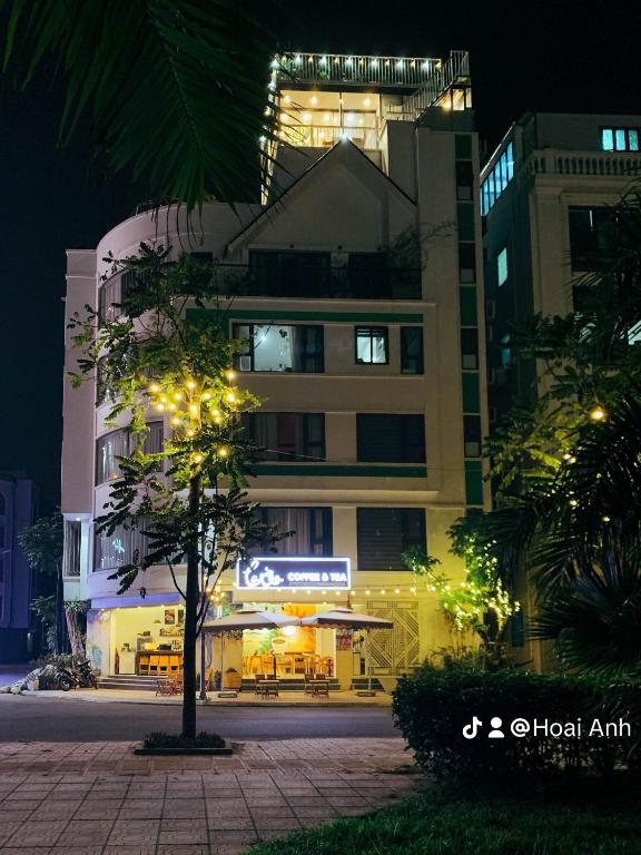 a building with a tree in front of it at night at Green Line Long Bien - Serviced Apartment - Ngoc Thuy - Hanoi in Hanoi