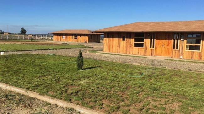 a group of wooden buildings in a field at Cabañas Madera del Confin Angol in Angol