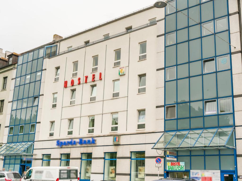 a large white building with a red sign on it at Babelfish Hostel in Würzburg