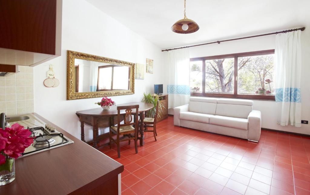 a kitchen and living room with a couch and a table at Pinus Village Appartamento in Santa Margherita di Pula