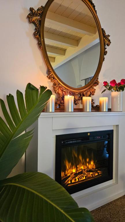 a fireplace with candles and a mirror above it at Le Stanze di Felline in Felline