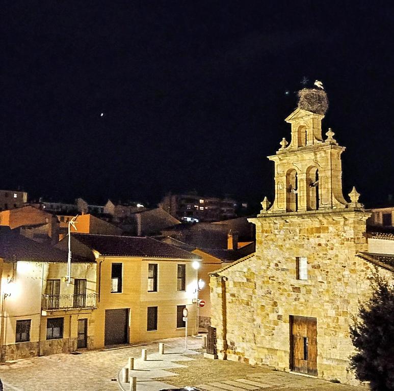 an old stone building with a clock tower at night at Mirador de las cigüeñas in Zamora