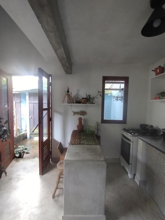 uma cozinha com um fogão e uma bancada em Chalé Mar Aberto em Porto Seguro