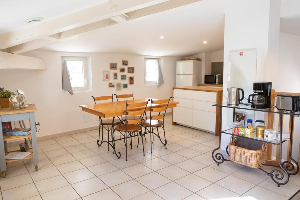 a kitchen and dining room with a table and chairs at Appartement spacieux Rochereau in L'Isle-sur-la-Sorgue