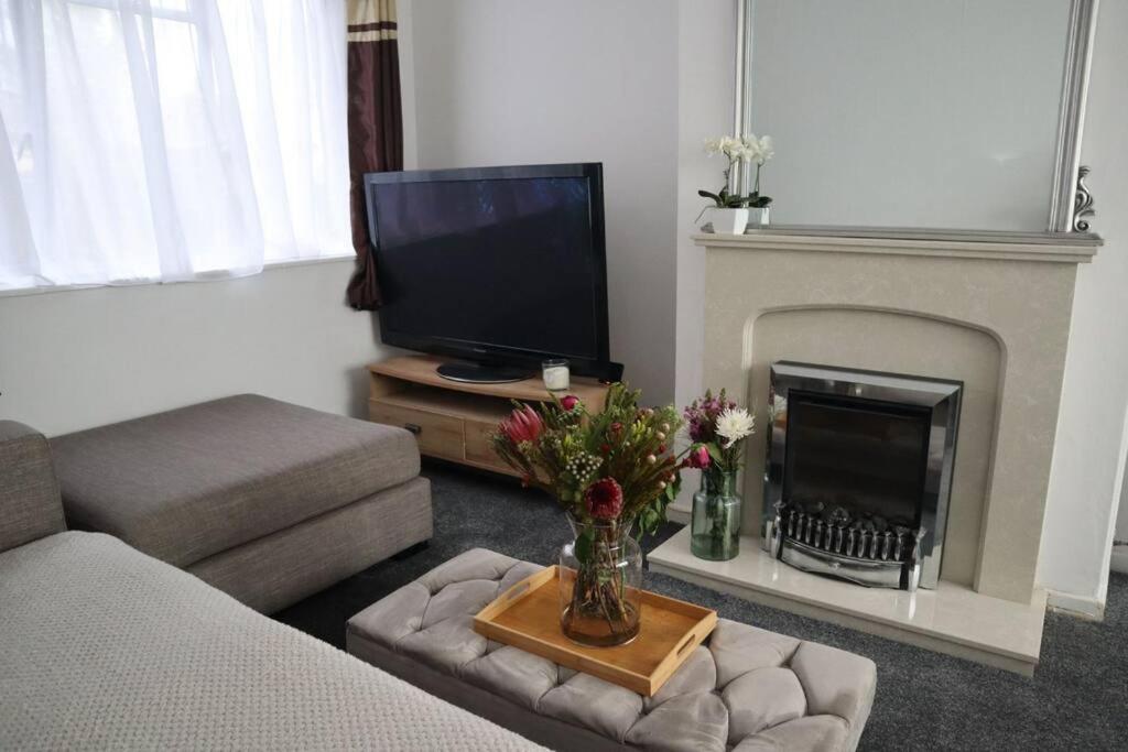 a living room with a tv and a fireplace at Charming 3Bed Home in High Barnet in Barnet