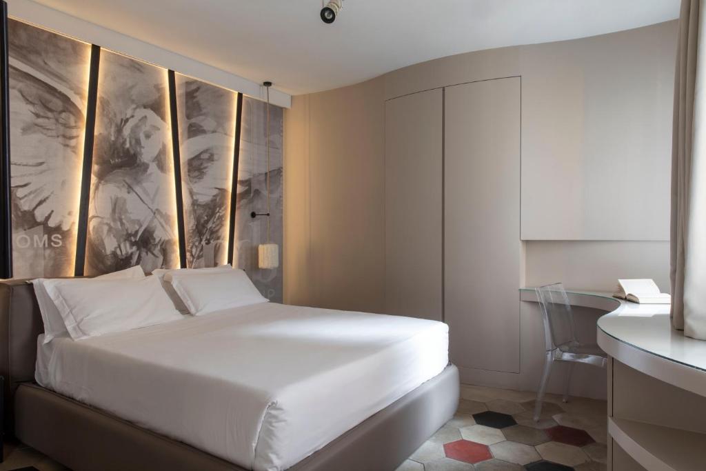 um quarto com uma cama branca e uma secretária em BDB Rooms Navona em Roma