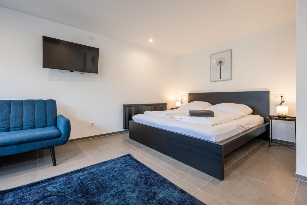 a bedroom with a bed and a blue chair at Studio U1 in bester Lage in Radolfzell am Bodensee