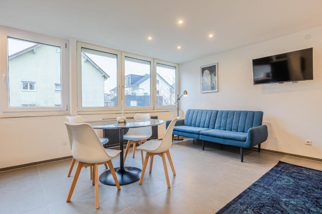 een woonkamer met een tafel en stoelen en een bank bij Studio U1 in bester Lage in Radolfzell am Bodensee