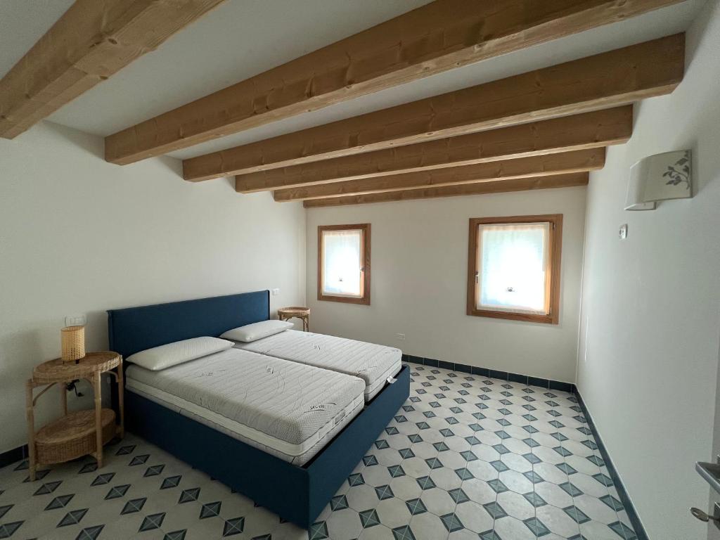 1 dormitorio con 1 cama en una habitación con techos de madera en Appartamento Fronte Laguna Ca’Nonica en SantʼAntonio