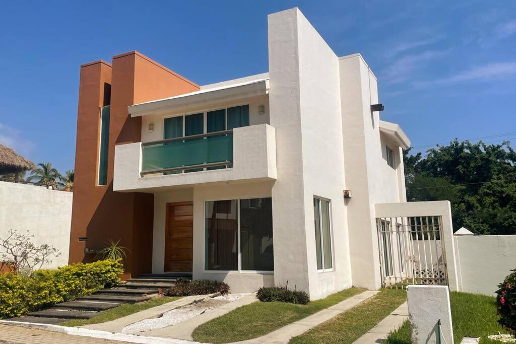 een groot wit huis met een blauwe lucht bij Casa Sirena 18 in Manzanillo