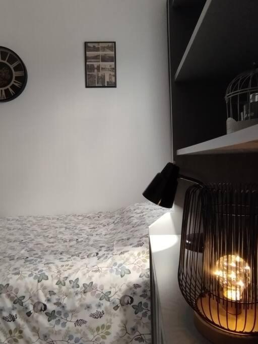 a bedroom with a bed and a bird cage at Le Studio de la Seine in Elbeuf