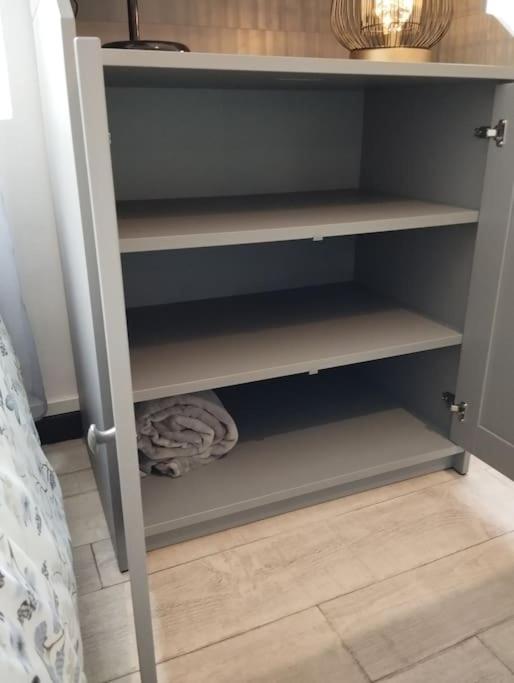 a cupboard withdrawers and shelves in a bedroom at Le Studio de la Seine in Elbeuf