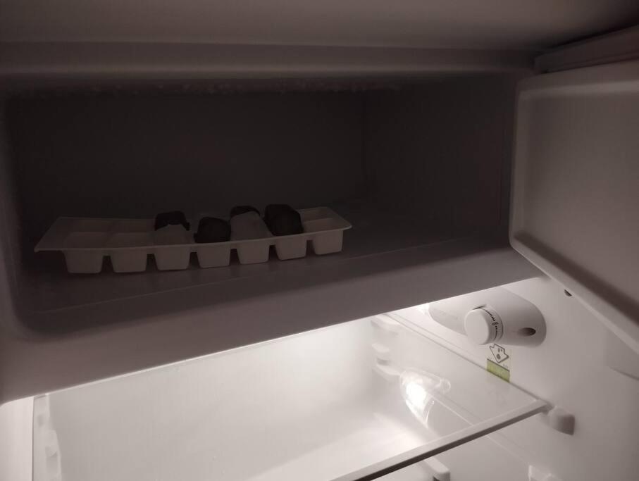 ein Regal in einem Kühlschrank mit etwas Essen drinnen in der Unterkunft Le Studio de la Seine in Elbeuf