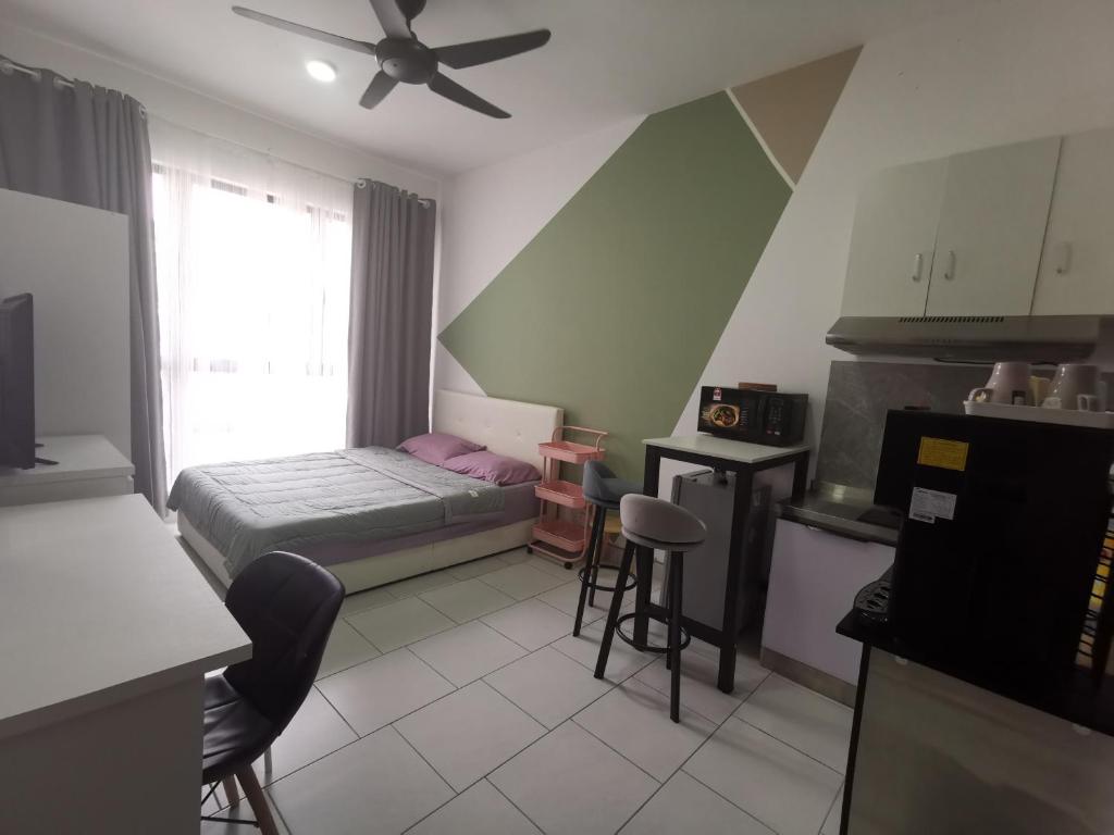 Una pequeña habitación con una cama y una cocina. en Studio@Astetica, en Seri Kembangan