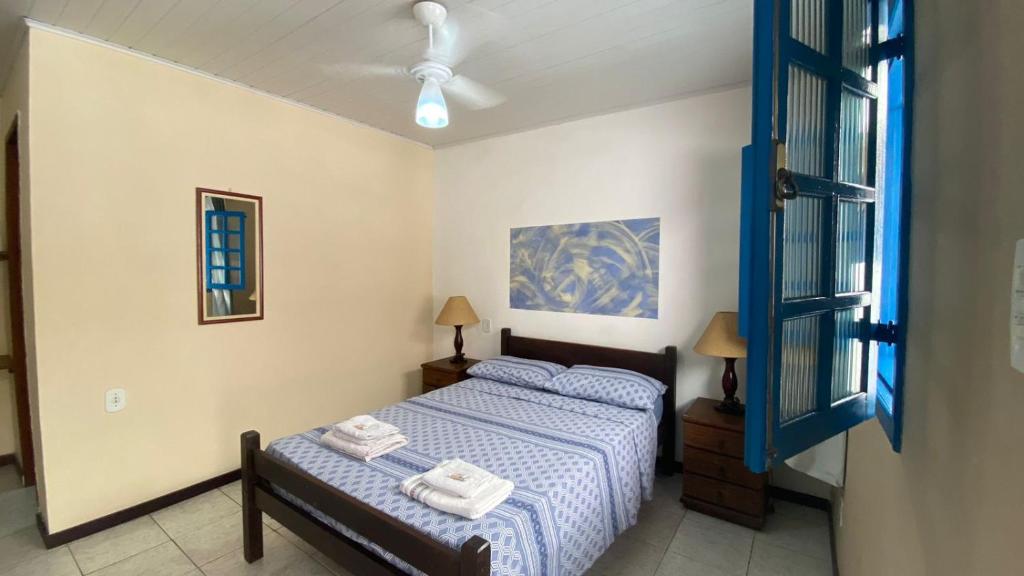 1 dormitorio con 1 cama con 2 toallas en Suítes no Centro, en Búzios