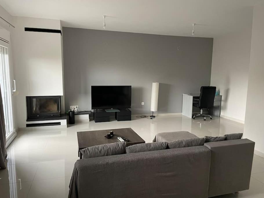 a living room with a couch and a tv at Luxurious 3rd floor apartment with elevator in Alexandroupoli