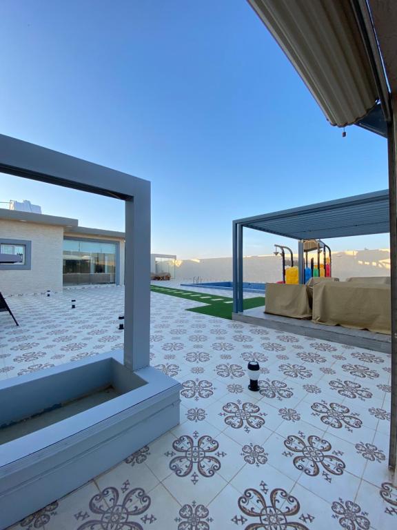 patio z podłogą wyłożoną kafelkami i widokiem na ocean w obiekcie شاليهات ملك w Rafhie
