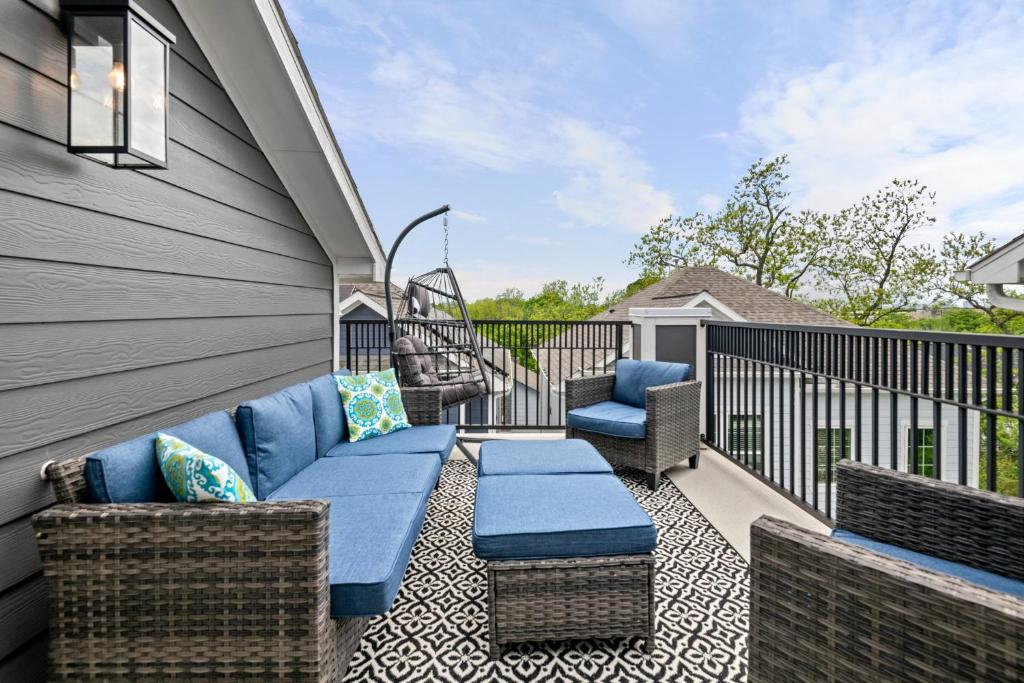 a patio with a couch and chairs on a balcony at Lux Living - East Downtown Rooftop with King Suite & Private Chef in Houston