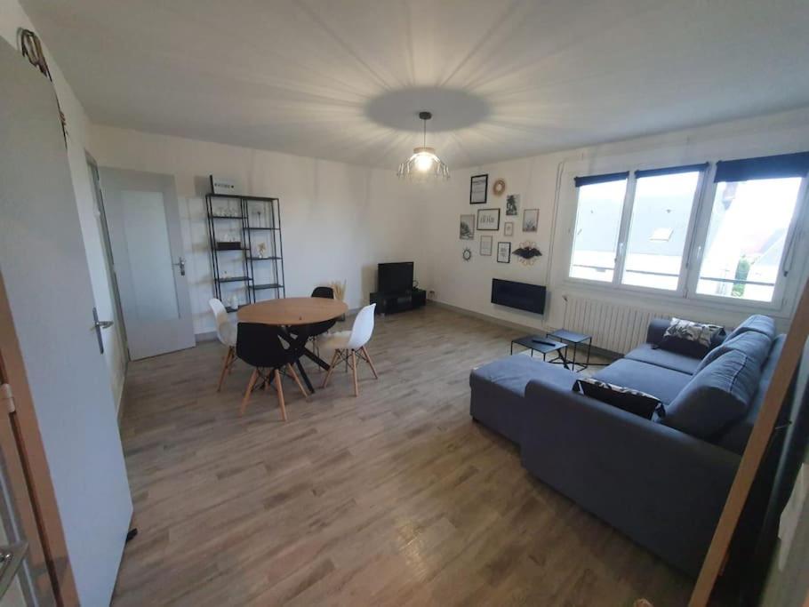 ein Wohnzimmer mit einem Sofa und einem Tisch in der Unterkunft Charmant appartement avec vue mer in Cherbourg en Cotentin