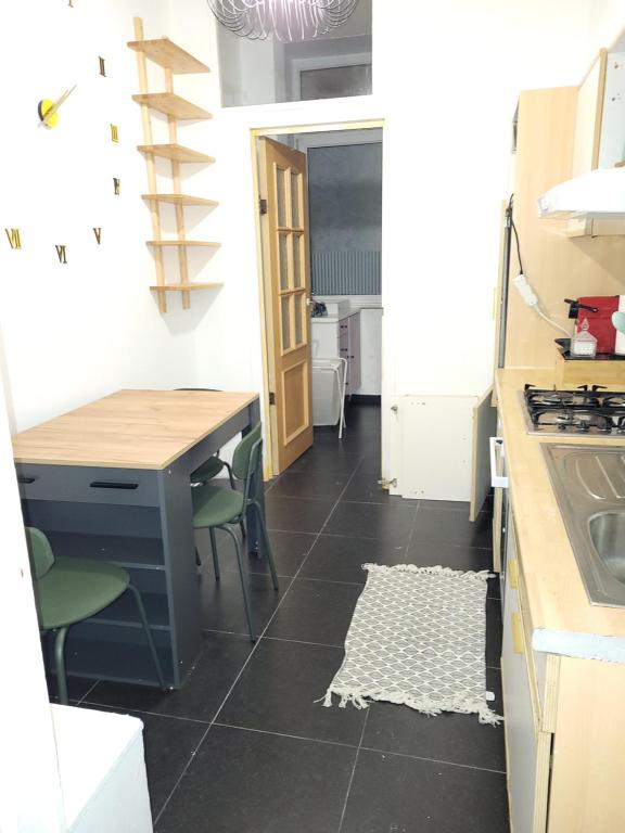 uma cozinha com uma secretária e uma mesa com cadeiras em appartement style haussmannien em Bruxelas