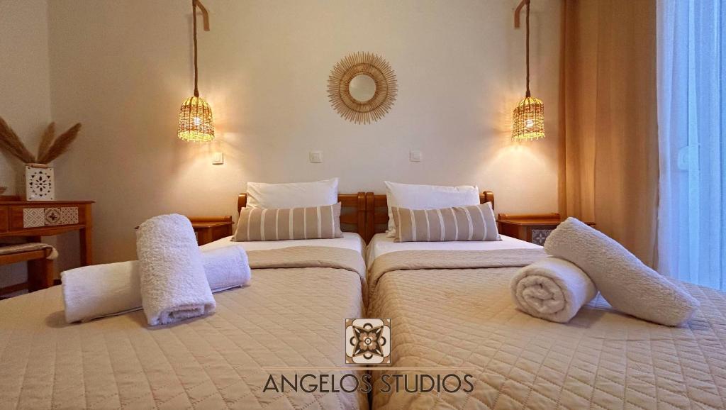 2 Betten in einem Hotelzimmer mit weißer Bettwäsche und Kissen in der Unterkunft ANGELOS STUDIOS 1-2 Ground Floor in Faliraki