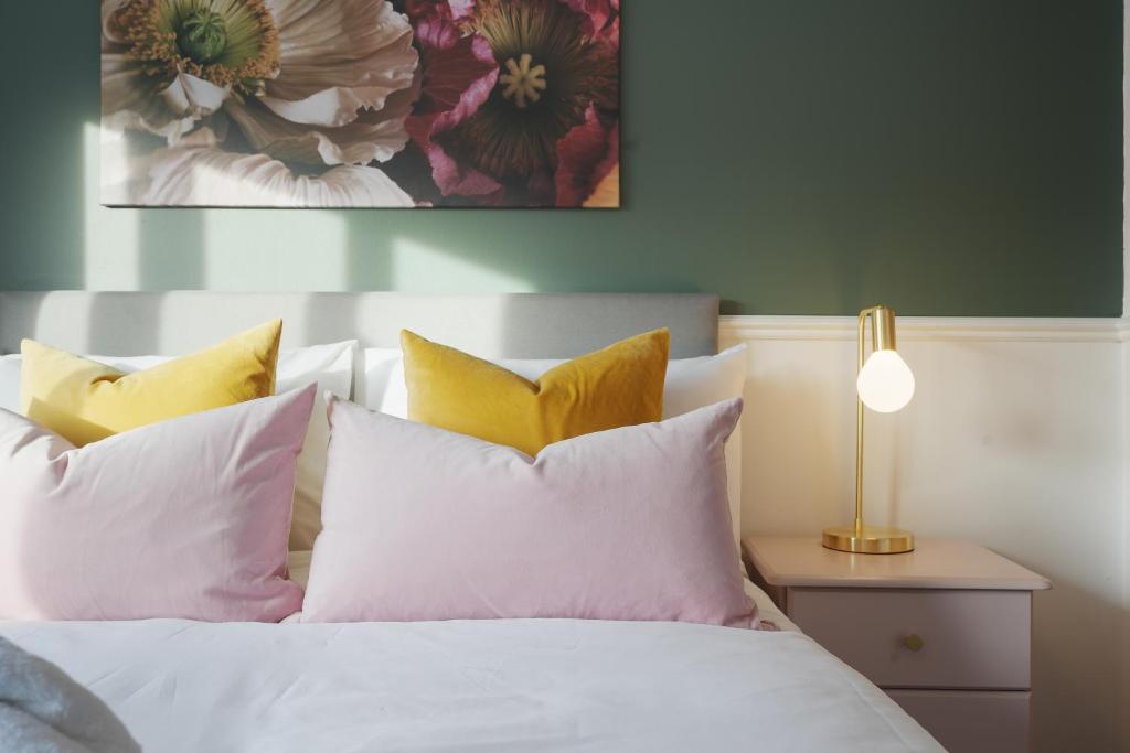 1 dormitorio con 1 cama con sábanas blancas y almohadas amarillas en Tapton View - Modern Stay Near Chesterfield Town Center, Train Station & the Peak District, en Brimington