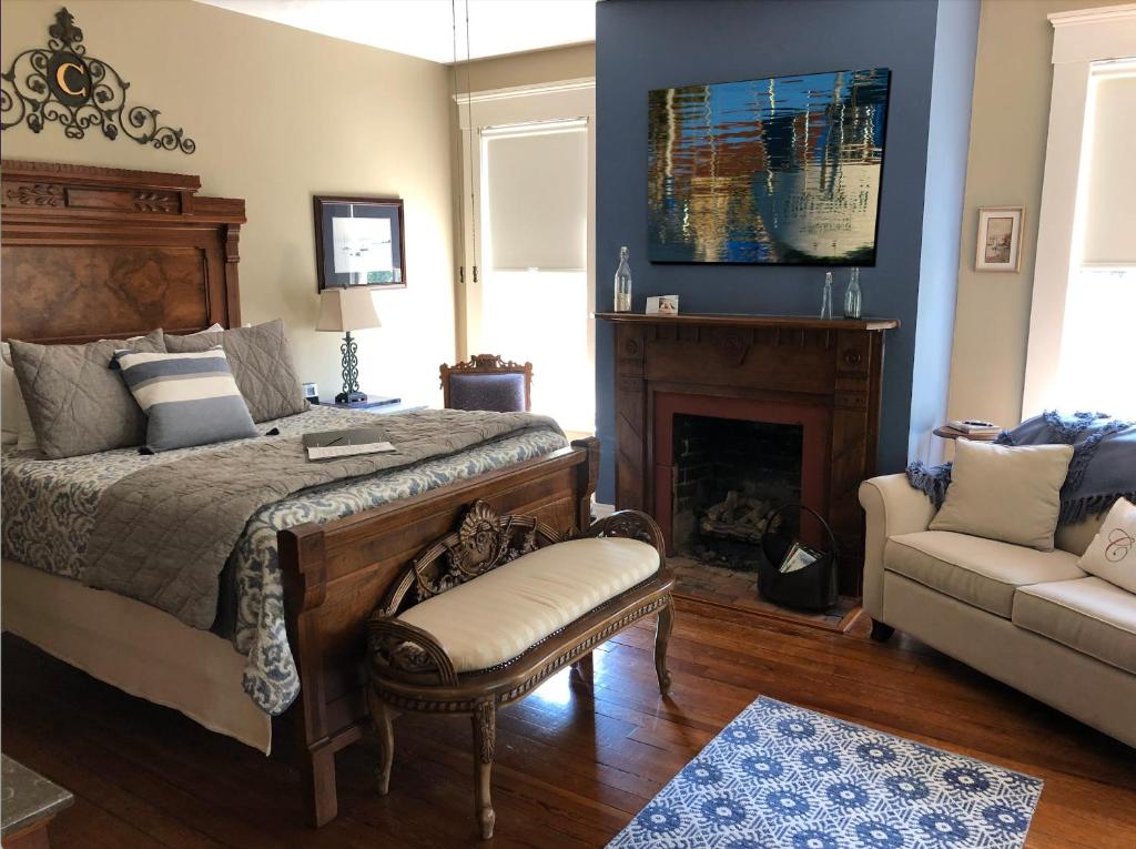 um quarto com uma cama, um sofá e uma lareira em Cumberland Suite em Gainesville