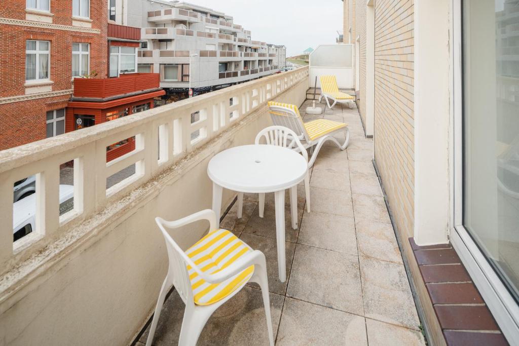 einen Balkon mit Stühlen und Tischen auf einem Gebäude in der Unterkunft Haus Tiemann Wohnung 2 in Norderney