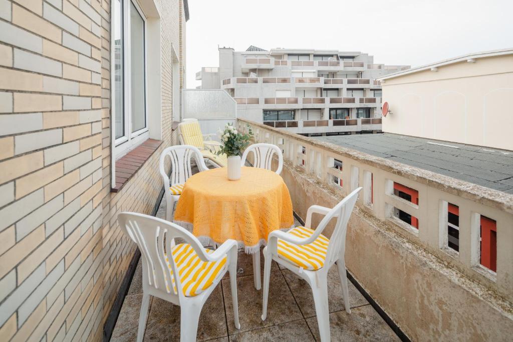 a table and chairs on a balcony with a view at Haus Tiemann Wohnung 7 in Norderney