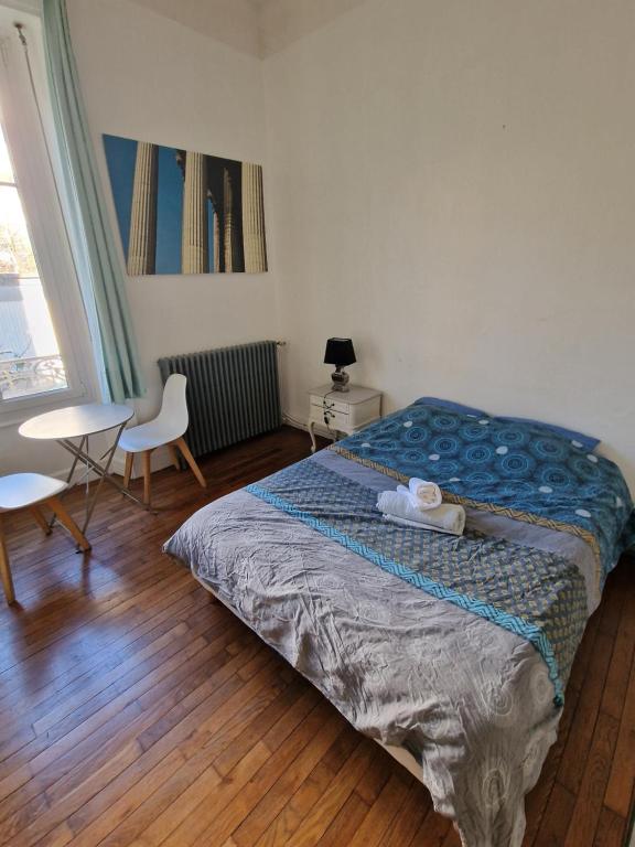 a bedroom with a bed and a table and a window at Le Klein, Studio au calme au centre de Besançon in Besançon