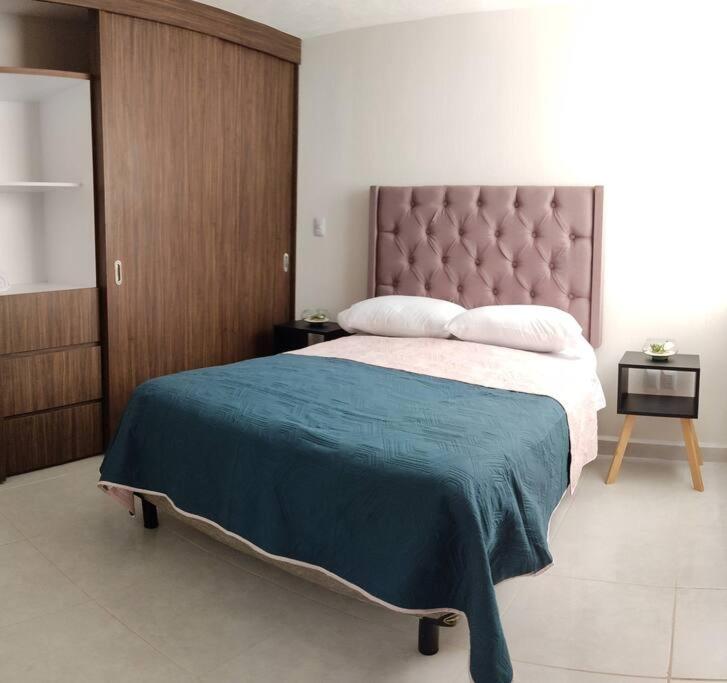 a bedroom with a large bed with a blue blanket at Dpto en Altozano 34 in Morelia