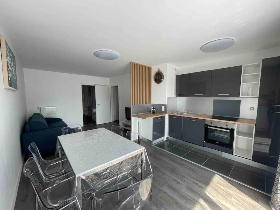 隆瑞莫的住宿－Appartement résidentiel Longjumeau，一间带桌子的客厅和一间厨房