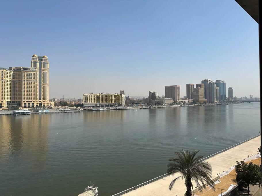 une grande étendue d'eau avec des bâtiments et une ville dans l'établissement Zamalek Retreat: Premium Stay with Nile View, au Caire