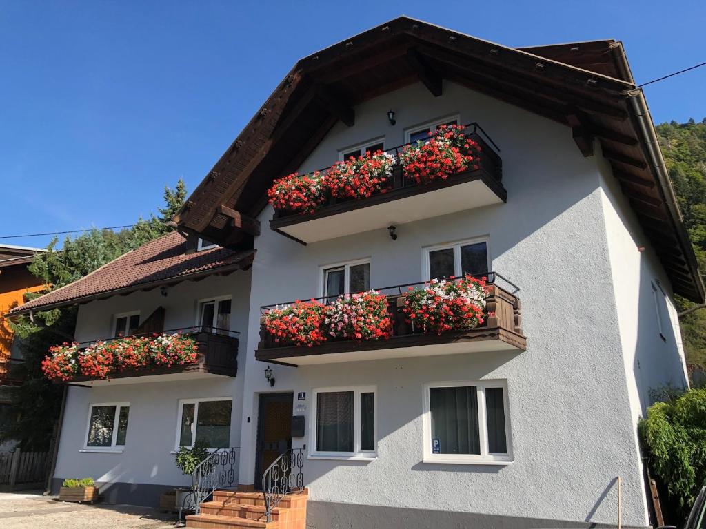 ein weißes Gebäude mit Blumenkästen auf den Balkonen in der Unterkunft Appartement Kuhglocken Ferienhaus Fuenf Sinne in Döbriach