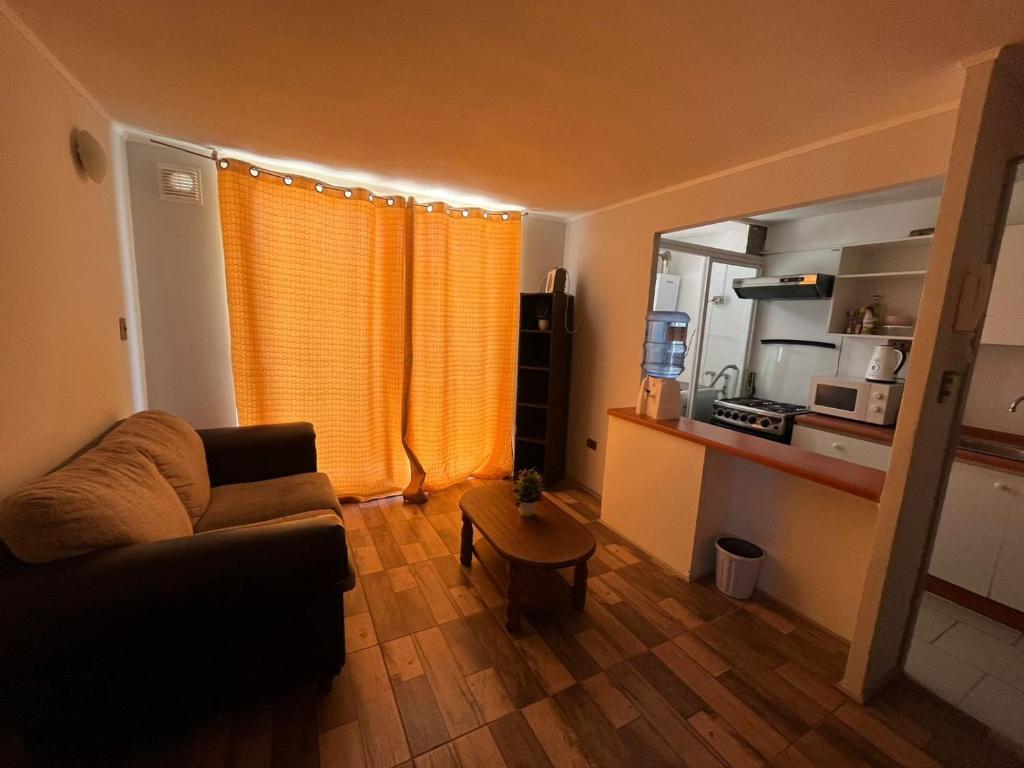 ein Wohnzimmer mit einem Sofa und einem Tisch in der Unterkunft Departamento Santa Beatriz,Huasco in Huasco